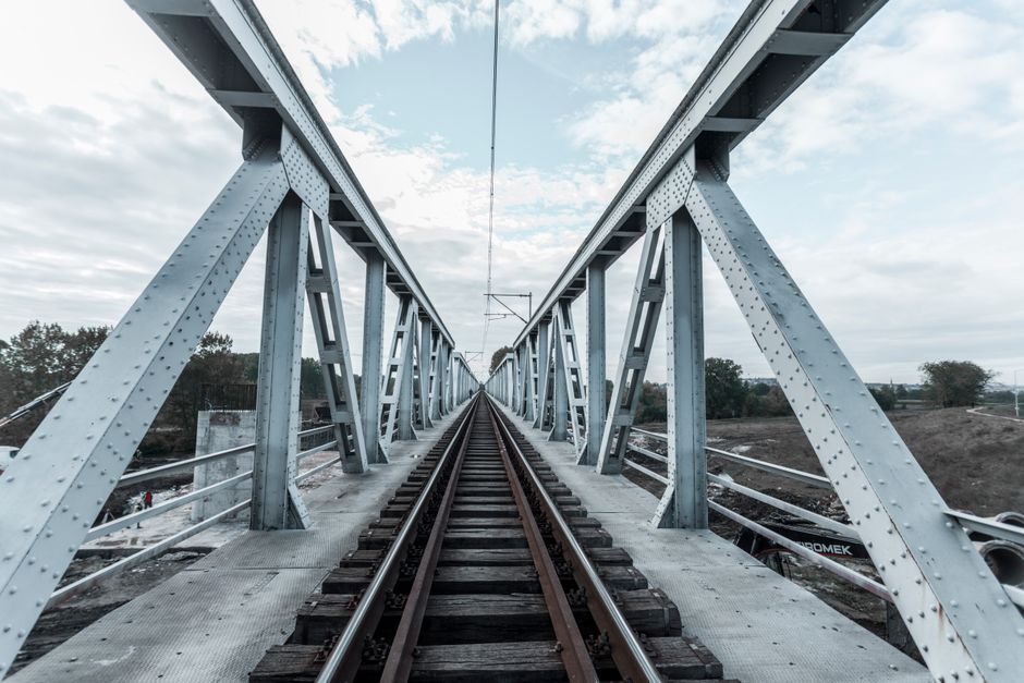 A captivating view down the tracks of an industrial steel railway bridge.