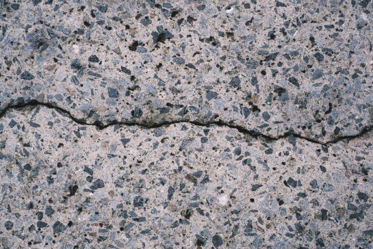 Detailed view of a textured concrete surface with visible aggregate and cracks.