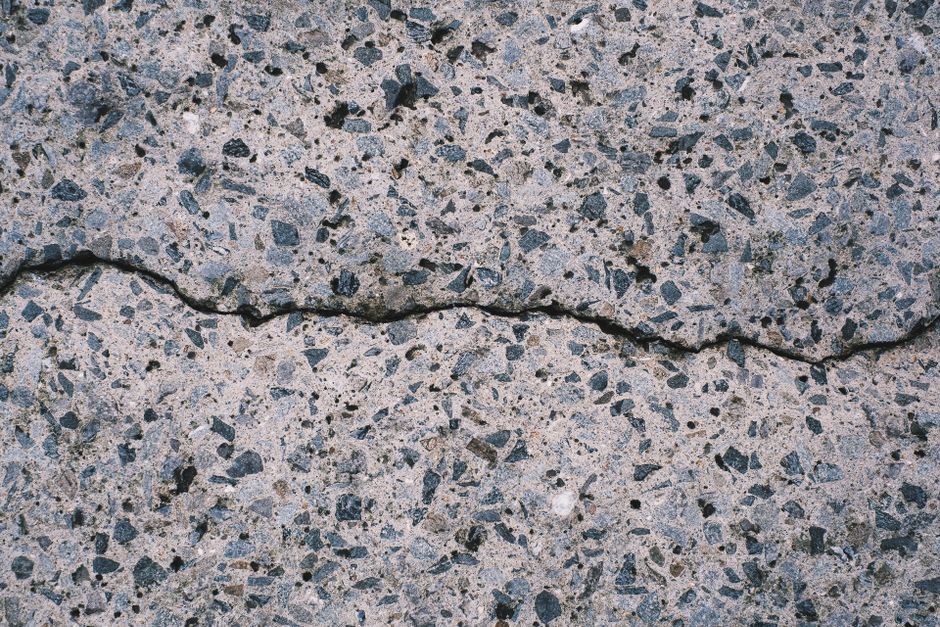 Detailed view of a textured concrete surface with visible aggregate and cracks.